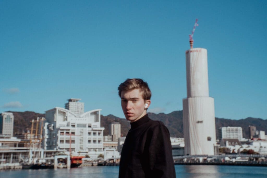 Noah poses with airpods in during his solo trip because he loves listening to music while solo traveling.