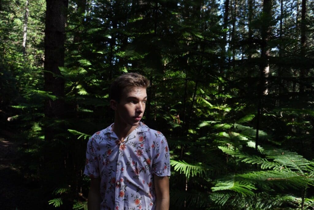 On the Hauula Loop Trail, Noah takes the world poses in the green pine trees. 