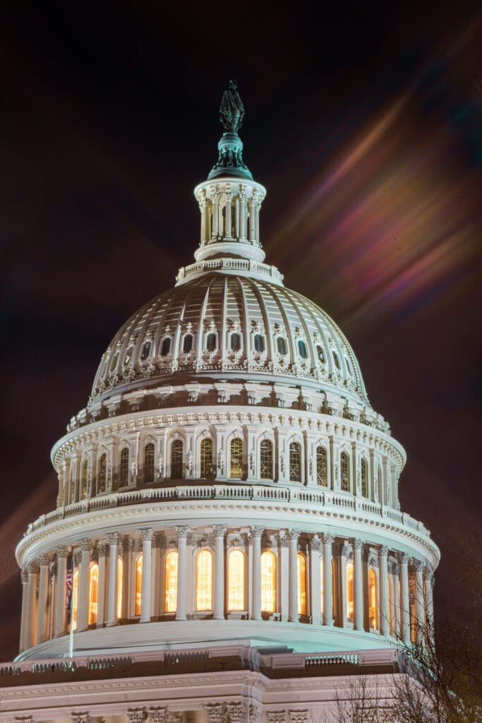 The tower of the Capitol building shines bright in a long exposure photo. 