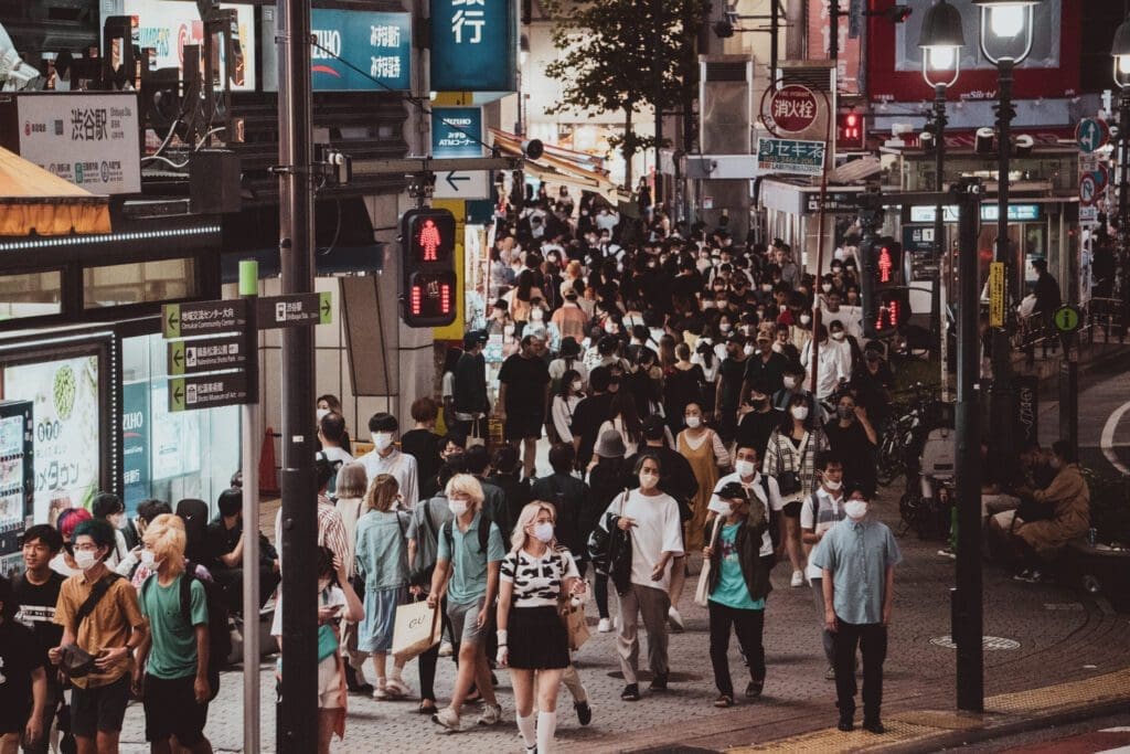 Many commuters rush in Shibuya at night. 