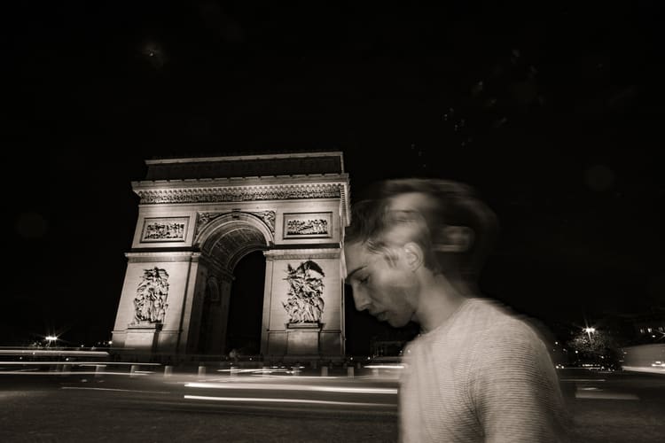 Noah takes a photo infront of the Arc de Triomphe.